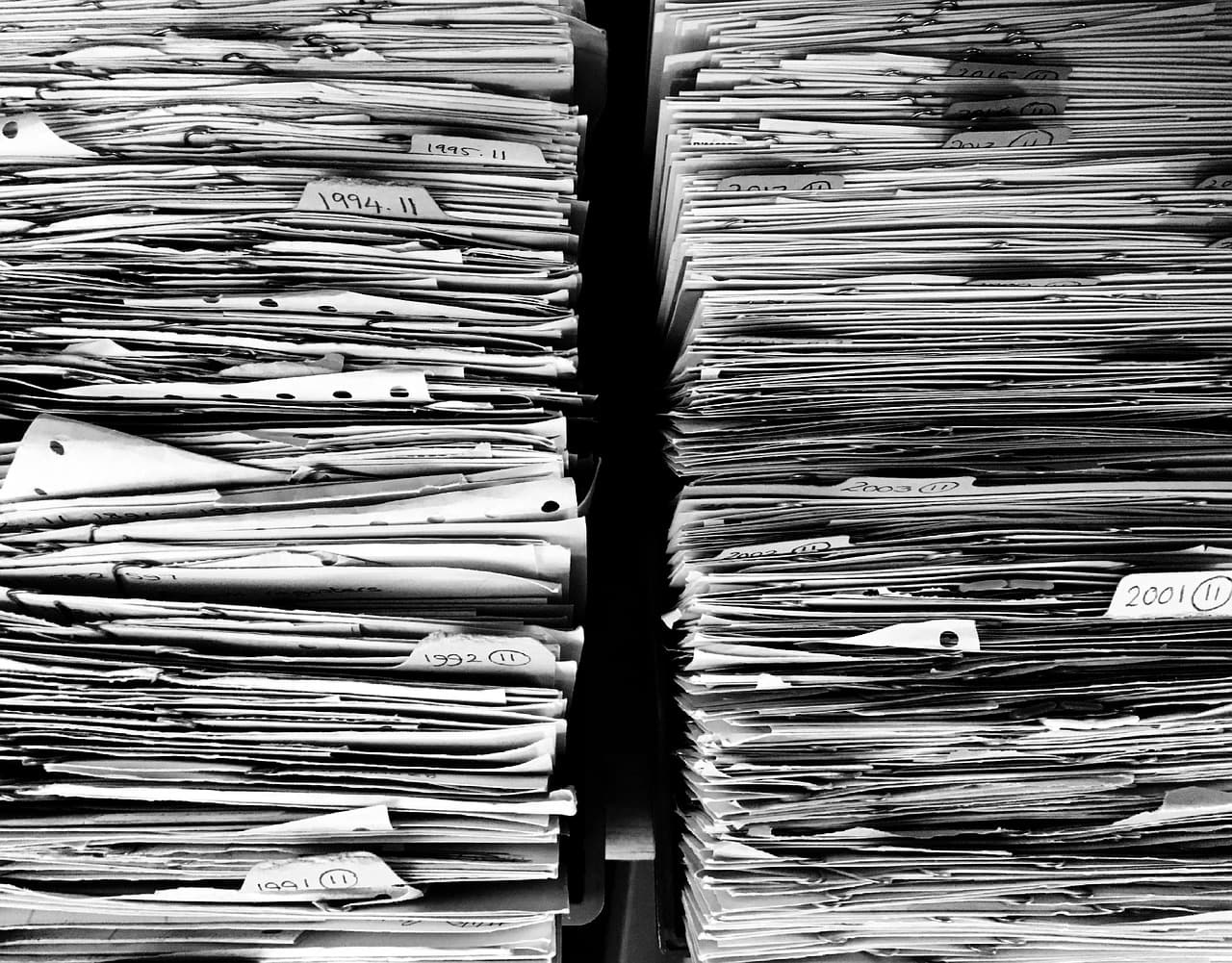 Stacked paper folders and files organised in an office archive